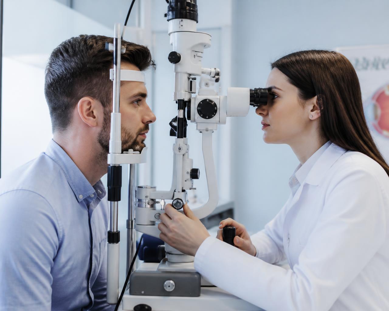 Ophthalmologist examining a patient at a slit lamp in a modern eye clinic